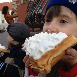 Plac Zamkowy, dzieci jedzą gofry, atrakcyjna turystka fotografuje Zamek Królewski